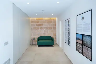 a green chair in a hallway with a brick wall at VILLAR Suites by Cadiz4Rentals in Cádiz