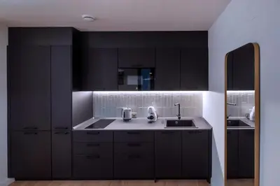 a black kitchen with a sink and a mirror at VILLAR Suites by Cadiz4Rentals in Cádiz