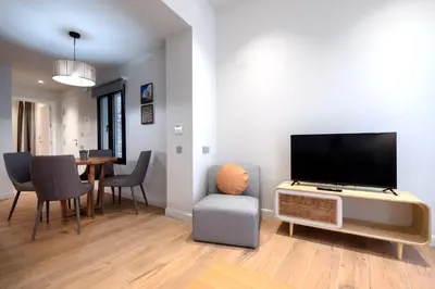 a living room with a television and a dining room table at VILLAR Suites by Cadiz4Rentals in Cádiz