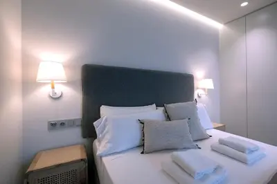 a bedroom with a bed with white pillows and two lamps at VILLAR Suites by Cadiz4Rentals in Cádiz