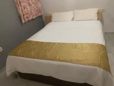 a bed with white sheets and a brown and white blanket at Casa Murillo in El Puerto de Santa María