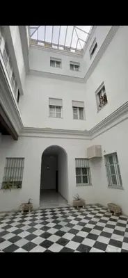 a large room with a checkered floor and a ceiling at Casa Murillo in El Puerto de Santa María