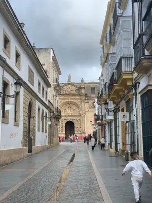 a child walking down a street in front of a building at Casa Murillo in El Puerto de Santa María