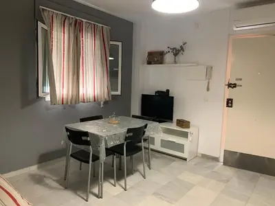 a dining room with a table and chairs and a television at Casa Murillo in El Puerto de Santa María