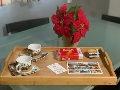 a table with two coffee cups and a book and flowers at Casa Murillo in El Puerto de Santa María