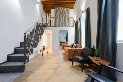 a living room with a staircase and a couch at Casa Manuel de Falla by Cadiz4Rentals in Cádiz