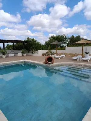 a large swimming pool with chairs and umbrellas at Las Vistas in Arcos de la Frontera