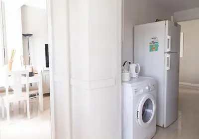 a kitchen with a white refrigerator and a washing machine at Al lado de la victoria in Cádiz