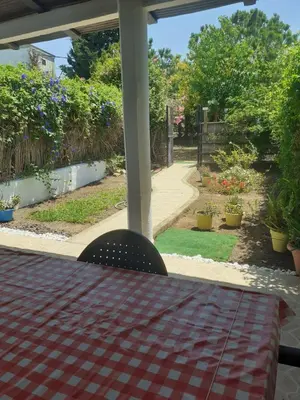 a table and chairs on a porch with a garden at Casa Marisa in Conil de la Frontera