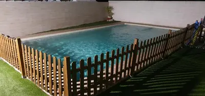 a swimming pool with a wooden fence around it at Villa Cristal in Chiclana de la Frontera