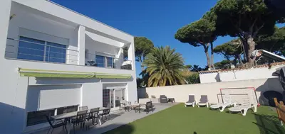 a white building with a yard with chairs and tables at Villa Cristal in Chiclana de la Frontera
