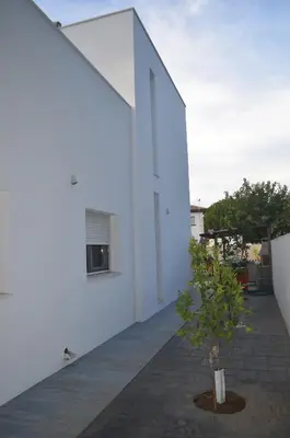 a white building with a small tree in a courtyard at Villa Cristal in Chiclana de la Frontera