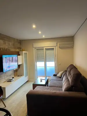 a living room with a couch and a flat screen tv at Apartamento de Reme Playa de la Barrosa in Chiclana de la Frontera