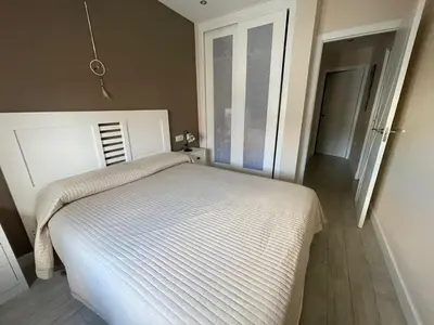 a white bed in a room with a window at Apartamento de Reme Playa de la Barrosa in Chiclana de la Frontera