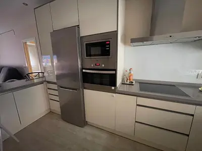 a kitchen with a stainless steel refrigerator and a microwave at Apartamento de Reme Playa de la Barrosa in Chiclana de la Frontera