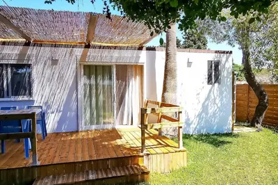 a house with a wooden deck in the yard at Apartamento Mery Oliva in Chiclana de la Frontera