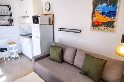 a living room with a couch and a kitchen at Apartamento Mery Oliva in Chiclana de la Frontera