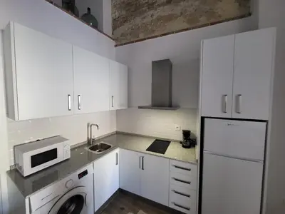a white kitchen with a sink and a microwave at Apartamento El Arrumbador in Jerez de la Frontera
