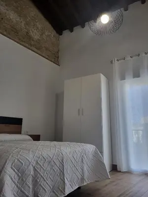 a bedroom with a bed and a white cabinet at Apartamento El Arrumbador in Jerez de la Frontera