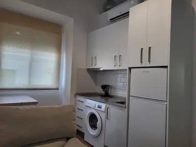 a kitchen with a white refrigerator and a washing machine at Apartamento La Albariza in Jerez de la Frontera