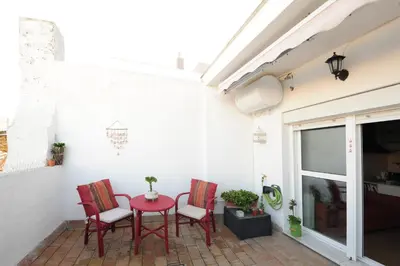 a patio with red chairs and a red table at Atico Brisa in Cádiz