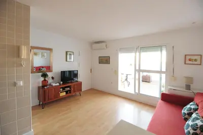 a living room with a red couch and a television at Atico Brisa in Cádiz