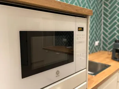 a microwave oven on a wall in a kitchen at Casa Sanlucar Centro in Sanlúcar de Barrameda