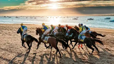 a group of people riding horses on the beach at Casa Sanlucar Centro in Sanlúcar de Barrameda