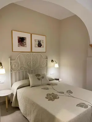 a bedroom with a bed and two pictures on the wall at Casa Sanlucar Centro in Sanlúcar de Barrameda