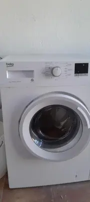 a white washing machine sitting in a room at PINZAPO in El Puerto de Santa María