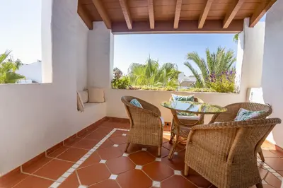 a balcony with a table and chairs and a view of the ocean at Ático Costa Ballena playa infante. 1º línea playa in Rota