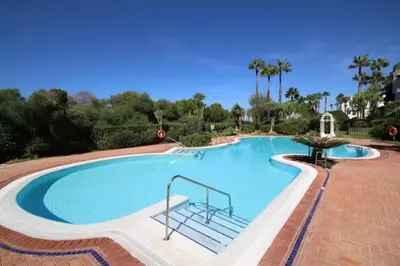 a large swimming pool with a chair in it at Ático Costa Ballena playa infante. 1º línea playa in Rota
