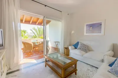 a living room with a couch and a table at Ático Costa Ballena playa infante. 1º línea playa in Rota