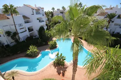 an overhead view of a swimming pool with palm trees at Ático Costa Ballena playa infante. 1º línea playa in Rota