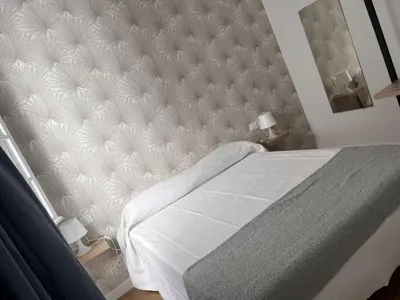 a bedroom with a large bed with a large headboard at apartamentos Larios centro in Sanlúcar de Barrameda