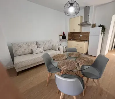 a living room with a couch and a table and chairs at apartamentos Larios centro in Sanlúcar de Barrameda