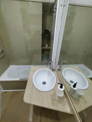 a bathroom with two sinks and a shower at apartamentos Larios centro in Sanlúcar de Barrameda