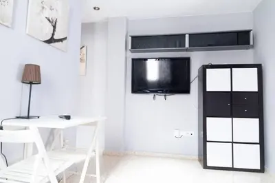a white room with a desk and a tv on the wall at Pasquín in Cádiz