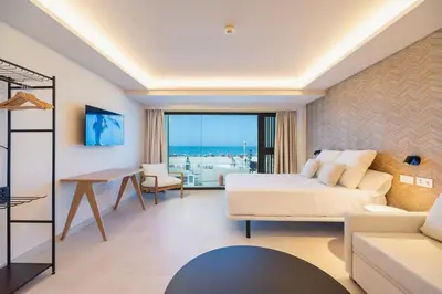 a bedroom with a bed and a living room at Apartamentos Playa Victoria - by Grupo Tribu in Cádiz