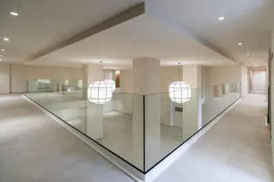 a hallway with a glass table and two pendant lights at Apartamentos Playa Victoria - by Grupo Tribu in Cádiz