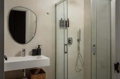 a bathroom with a shower and a sink and a mirror at BYPILLOW Casa Gades in Cádiz