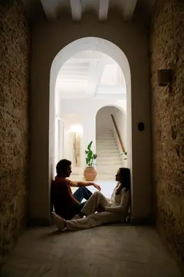 a man and woman sitting in an archway in a room at BYPILLOW Casa Gades in Cádiz