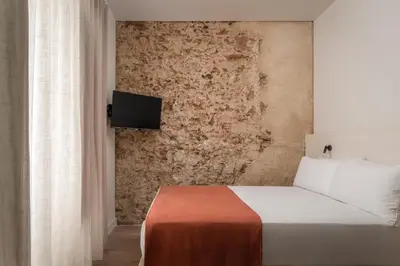 a bedroom with a bed and a tv on a wall at BYPILLOW Casa Gades in Cádiz