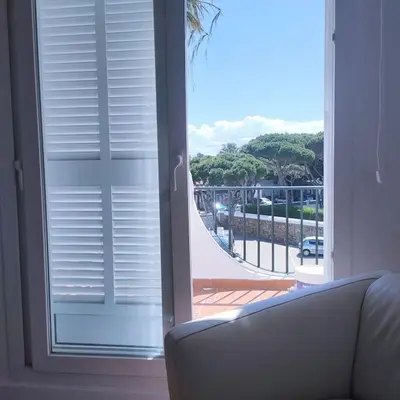 a living room with a couch and a large window at Apartamento Luz in Chiclana de la Frontera
