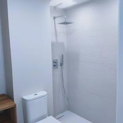 a white bathroom with a shower and a toilet at Apartamento Luz in Chiclana de la Frontera
