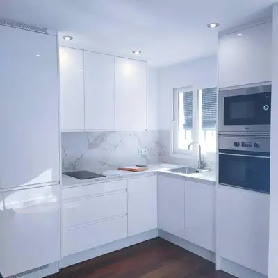 a white kitchen with white cabinets and a window at Apartamento Luz in Chiclana de la Frontera
