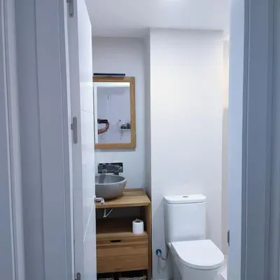 a bathroom with a white toilet and a sink at Apartamento Luz in Chiclana de la Frontera