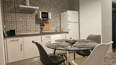 a kitchen with a table and chairs and a refrigerator at Apartamento Casa Pura in Medina Sidonia