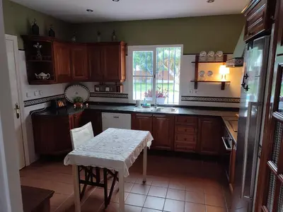 a kitchen with wooden cabinets and a table in it at EL RETIRO in Sanlúcar de Barrameda
