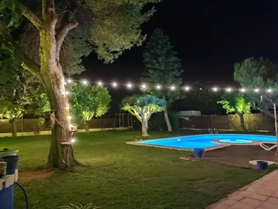 a backyard at night with a swimming pool and lights at EL RETIRO in Sanlúcar de Barrameda